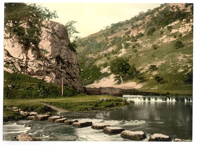 Photo a river runs through a mountain with a waterfall in the background