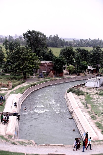 Photo a river runs through a village with a small house in the background.