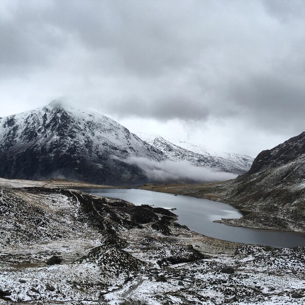 河流和雪山在云的天空之下