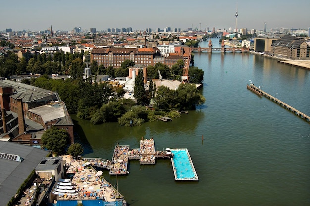 River Spree with the Badeschiff bathing ship Oberbaumbruecke and skyline of Berlin Mitte Berlin Germany