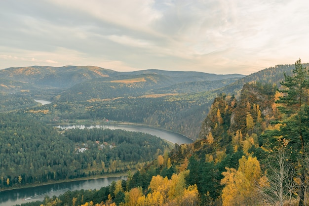 River valley on the background of beautiful mountains in autumn. Bird`s-eye view.