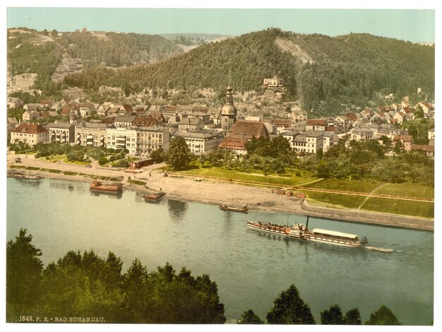 Photo a river with a boat and a city in the background