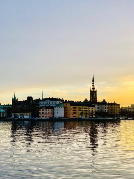 Photo river with buildings in background at sunset