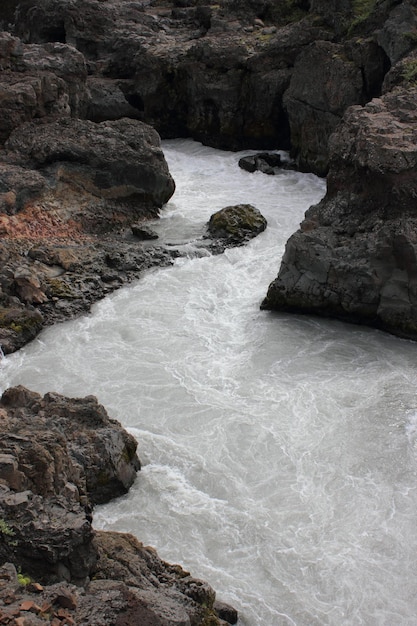 Photo a river with a rock face and a river with a white substance on it.