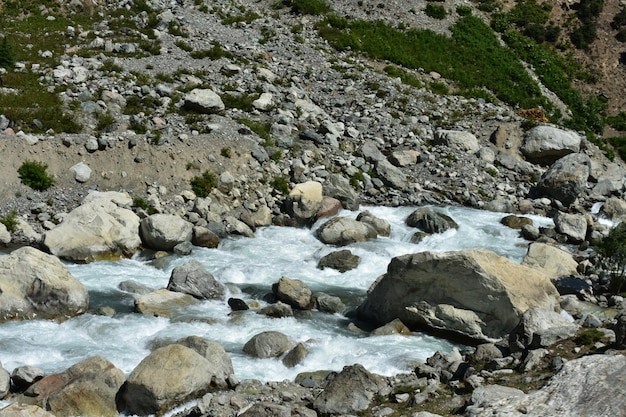 A river with rocks and a large rock on the side