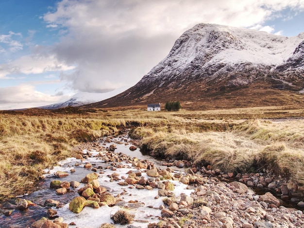 Rivier aan de voet van besneeuwde bergen in de Schotse hooglanden bij Glencoe in de winter koude winter ochtend