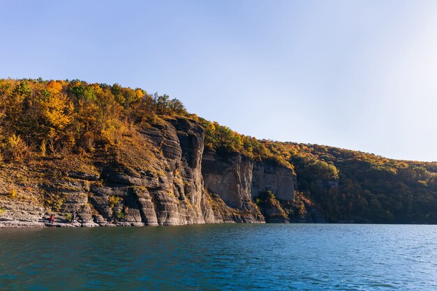 Rivier en rotsen aan de kust bedekt met herfst bos.