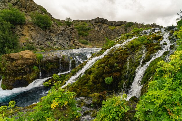 Foto rivier stroomt over ruw terrein en creëert meerdere kleine watervallen