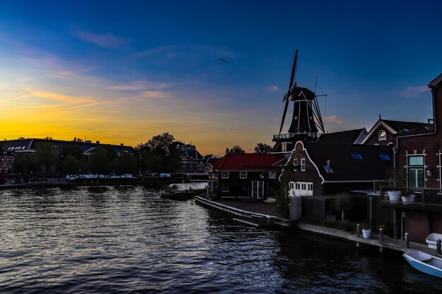 Foto rivier te midden van gebouwen tegen de hemel bij zonsondergang