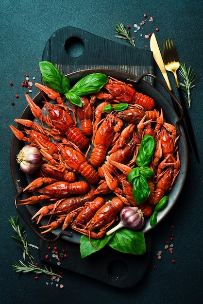 Rivierkreeft Rode gekookte langoesten in een kom met rozemarijn en kruiden op een donkere achtergrond Vrije ruimte voor het recept