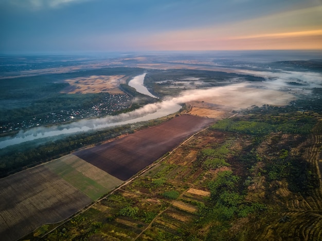 Rivierlandschap in de vroege ochtend een hut in de verte en de boom bedekt met mystieke mist heel stil...