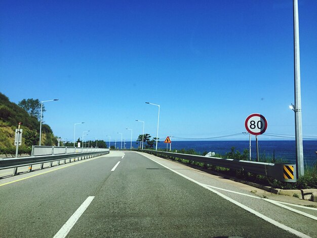 Road against clear blue sky