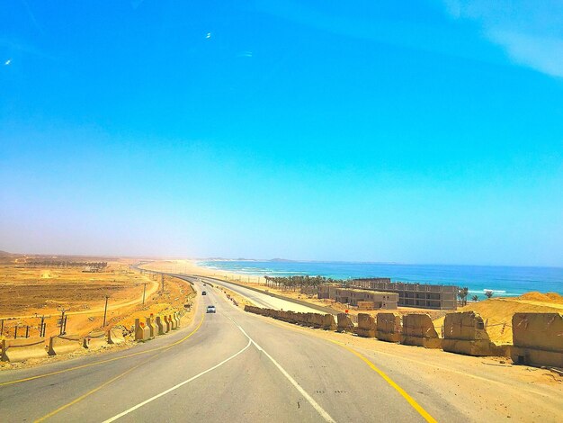 Road against clear blue sky