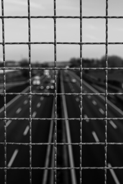 Photo road against sky seen through metal grate