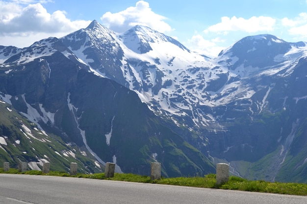 Road in Alp mountains in summer snow on peaks