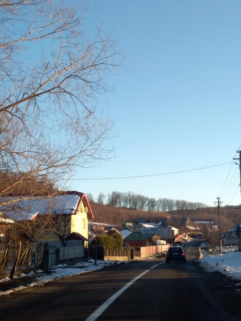 Photo road amidst buildings against sky during winter