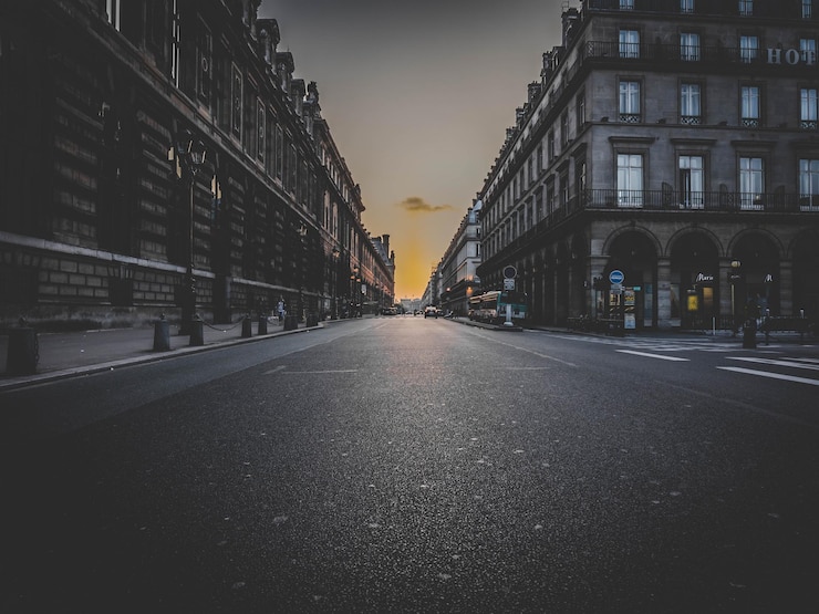 Photo road amidst buildings in city during sunset