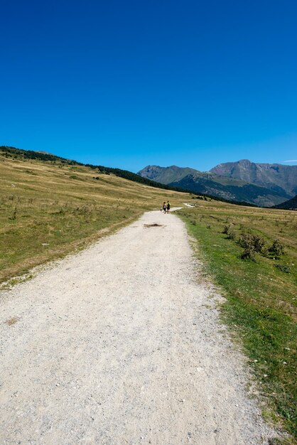 Foto strada in mezzo al campo contro un cielo blu limpido