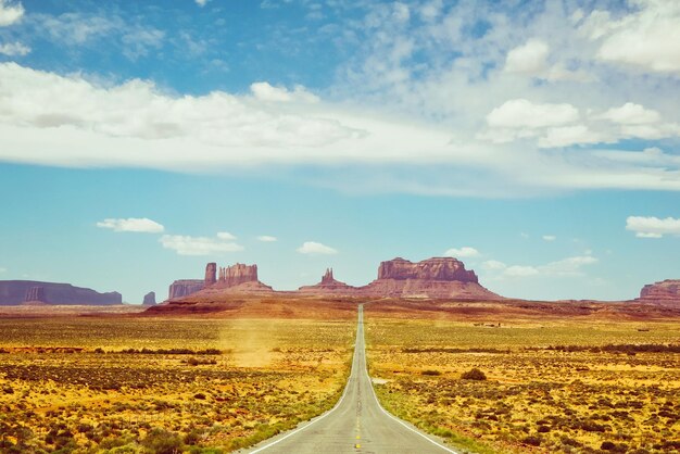 Road amidst field against sky