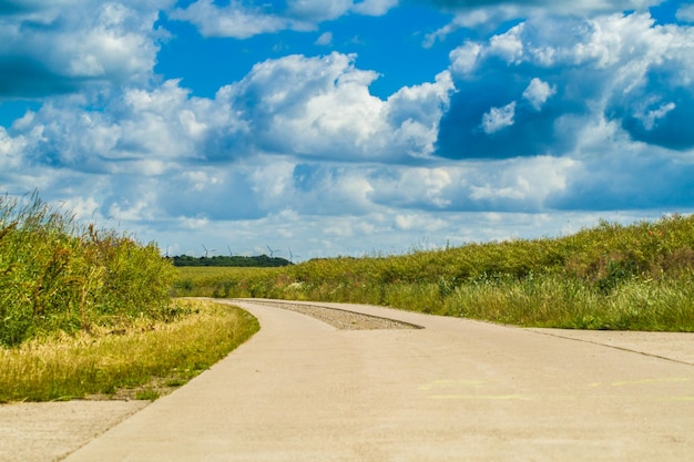 Road amidst field against sky