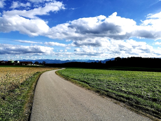 Photo road amidst field against sky