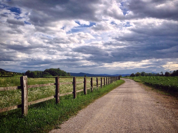 road amidst field against sky