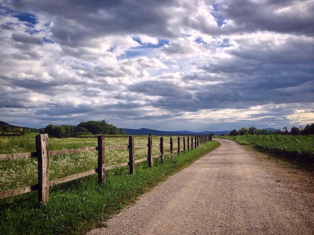 Photo road amidst field against sky