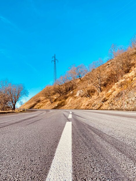 Foto strada in mezzo al campo contro il cielo