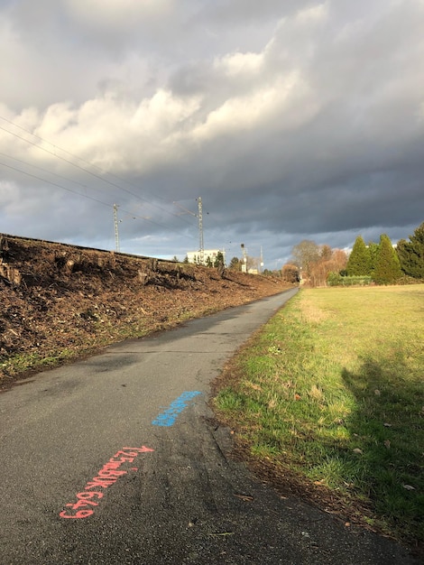 Photo road amidst field against sky