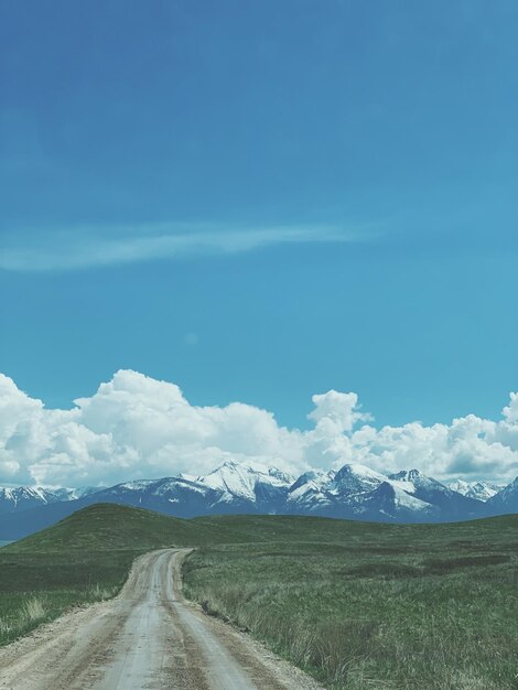 Road amidst field against sky