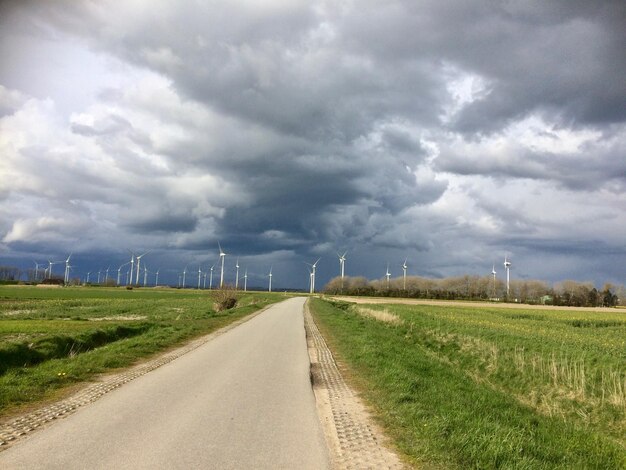 Road amidst field against sky