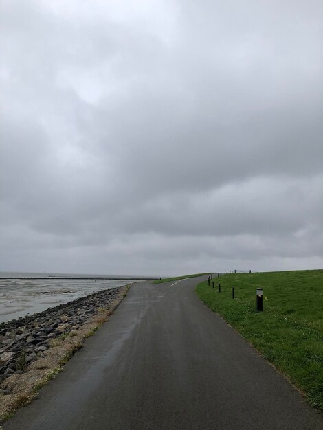 Road amidst land against sky