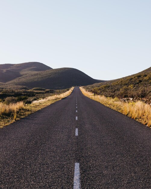 Foto strada in mezzo al paesaggio contro un cielo limpido