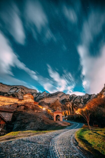 Photo road amidst landscape against sky at night