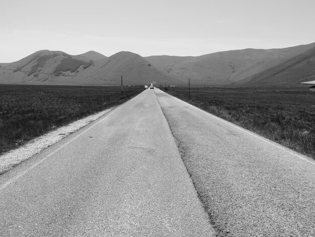 Photo road amidst landscape against sky