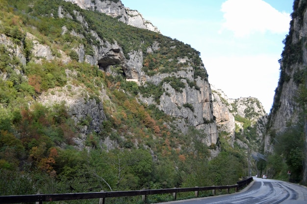 Photo road amidst rocks and trees against sky