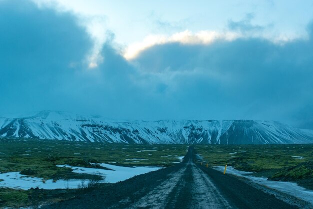 写真 空に逆らって雪に覆われた山の中の道