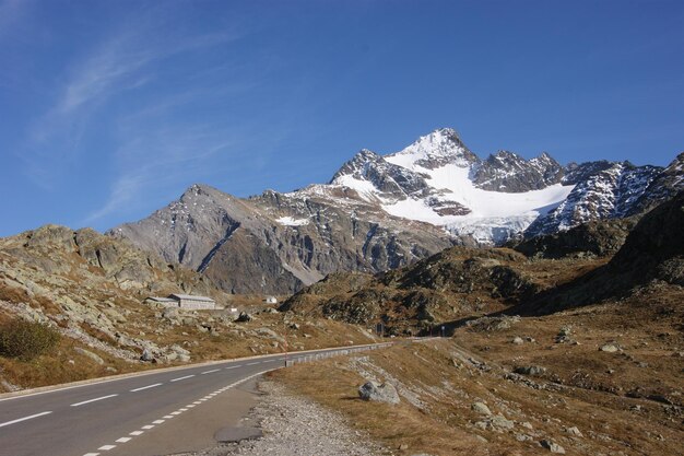 Road amidst snowcapped mountains against sky