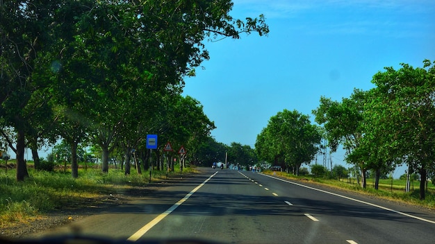 Photo road amidst trees against sky