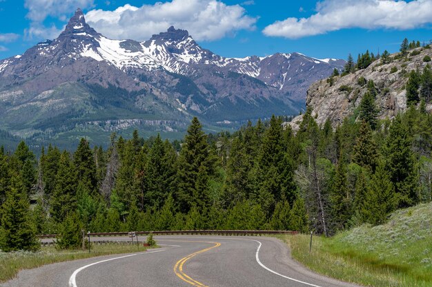 Photo road amidst trees and mountains against sky