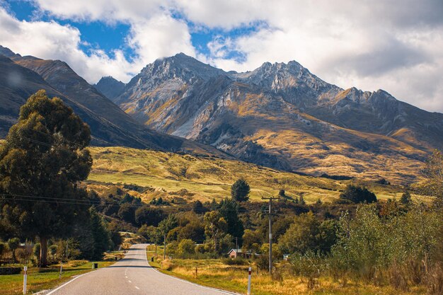 Road amidst trees and mountains against sky