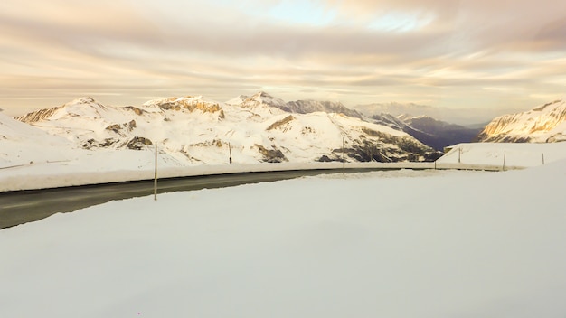 Foto la strada tra la neve sulla montagna al tramonto