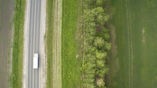 写真 ロードとフィールドのトップビュートップビューの航空写真と高速道路に沿って移動する道路車