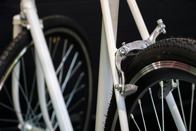 Road bike in the workshop Bicycle repair White bicycle on a black background Installation of new equipment Tire and rear brake closeup Preparations for the competitions