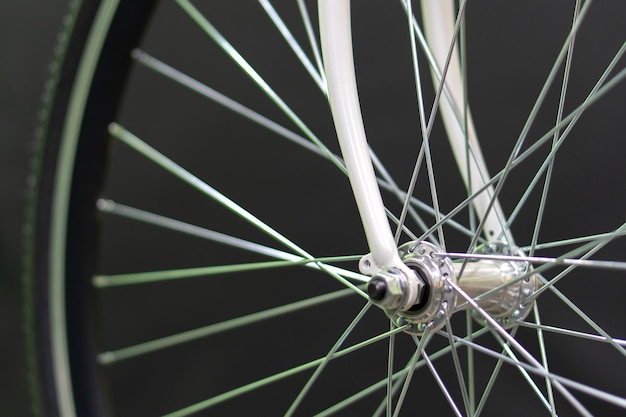 Road bike in the workshop Road bike wheel on a black background New fashionable beautiful bike Means for movement for active people Healthy life