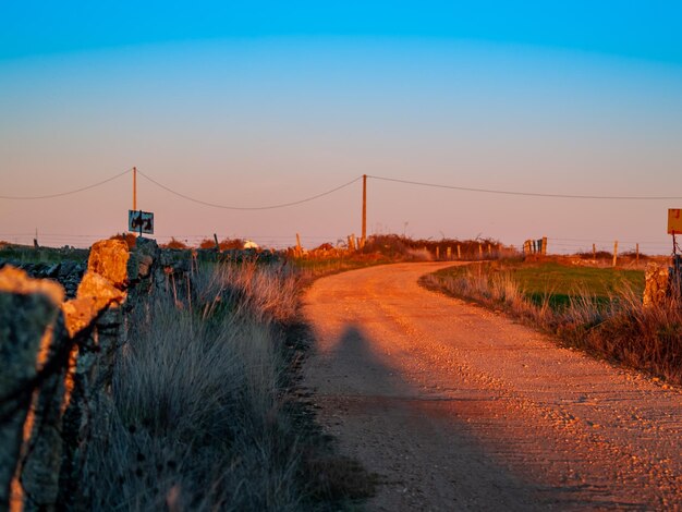 Photo road by bridge against clear sky during sunset