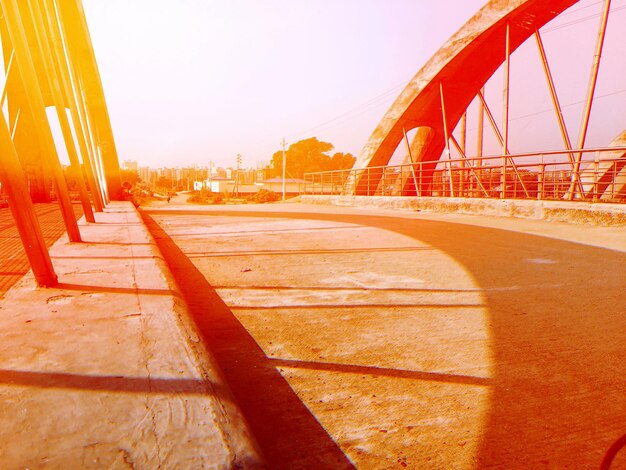 Road by bridge against sky in city