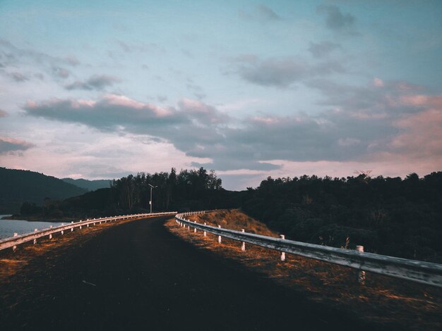 Road by bridge against sky