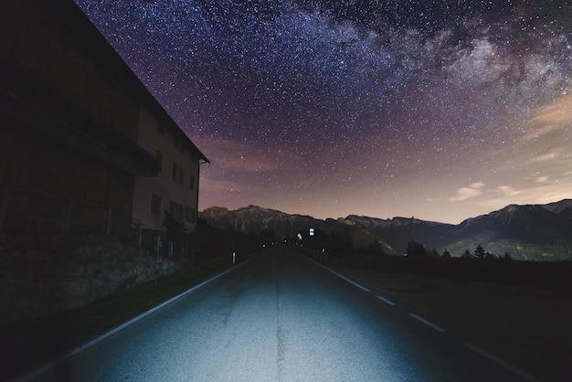 Road by building against star field at night