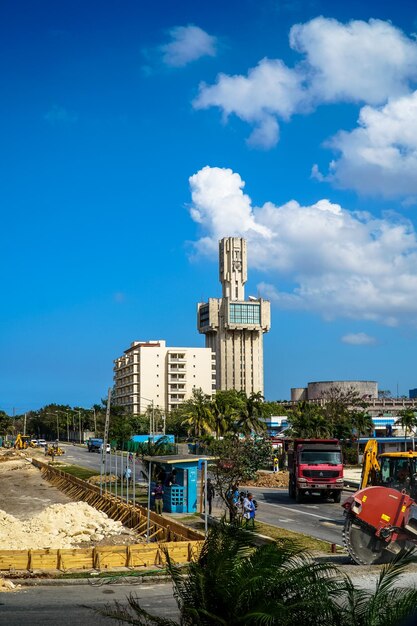 Road by buildings against blue sky